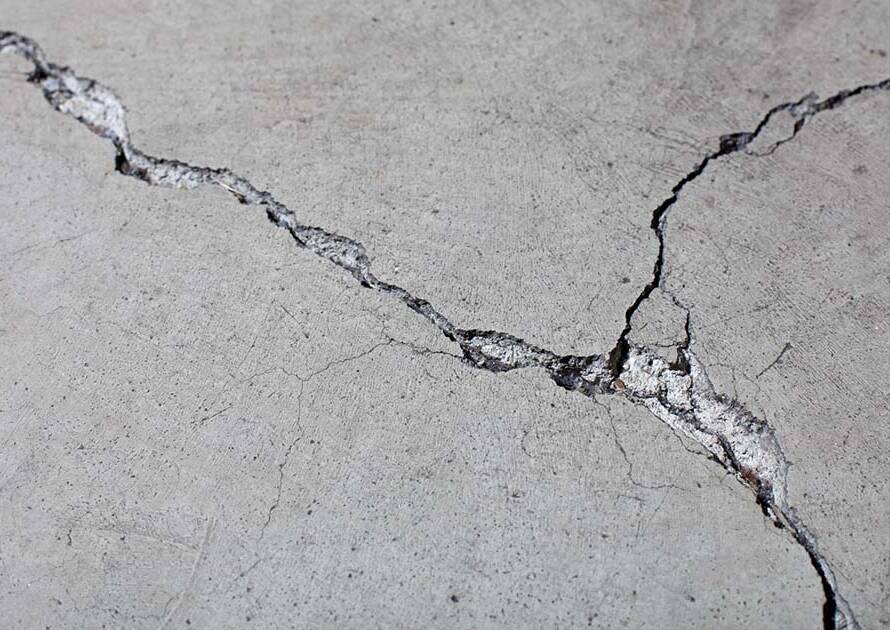 Freeze-thaw crack damage on unsealed concrete garage floor in Wichita, Kansas